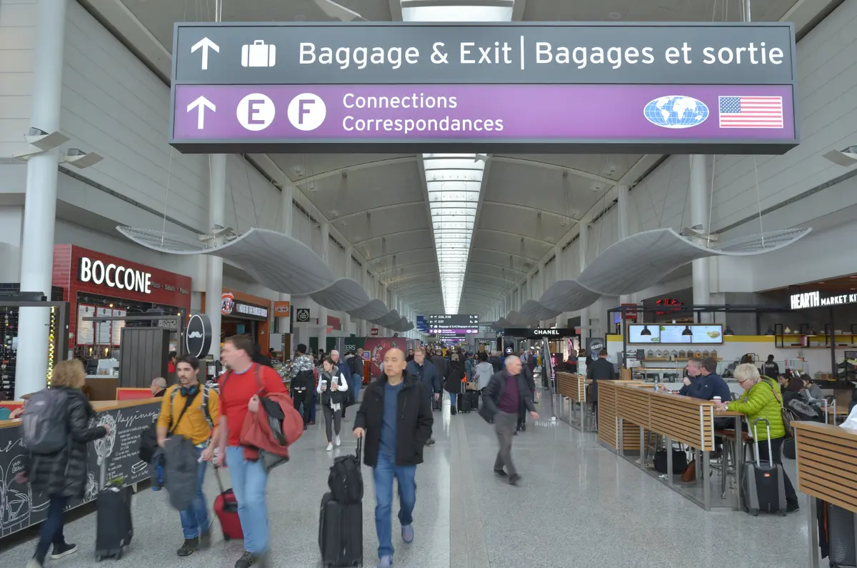 Viajantes caminhando com malas dentro de um terminal de aeroporto