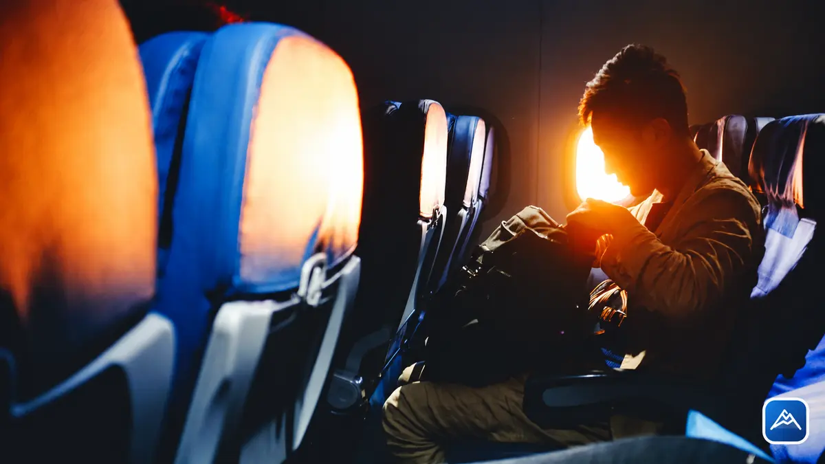 Passageiro dentro de um avião ao pôr do sol organizando sua bagagem